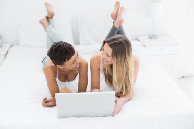 yatakta dizüstü kullanarak rahat mutlu arkadaşlar