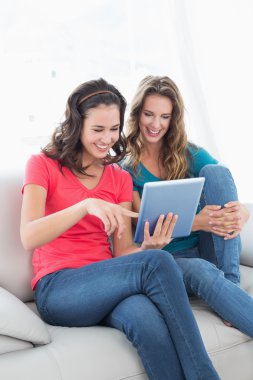 oturma odasında dijital tablet kullanan arkadaşlar