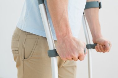 orta bölümde bir adamın koltuk değneği ile yan görünüm