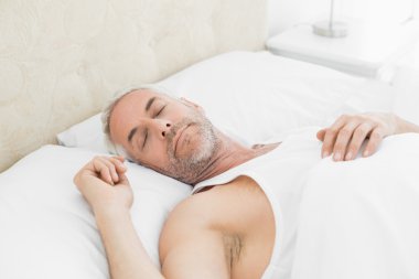 evde yatakta uyuyan olgun adam