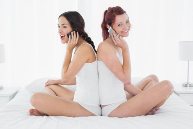 yatağa geri otururken cep telefonuyla arkadaşlar