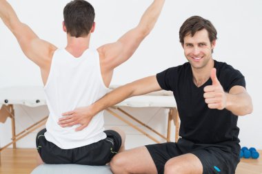 terapist jestleri başparmak yukarıya yanında yoga topu on adamım