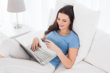 casual kadın yatakta online alışveriş yaparken