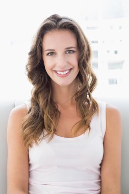 koltukta oturan genç gülümseyen bir kadın portresi