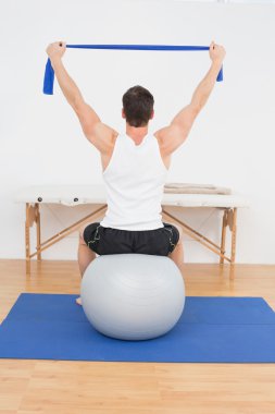 Dikiz yoga topu üzerinde oturan bir genç adam