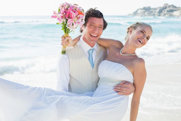 Skrattar brudgummen bär hans ganska blond fru ler mot kameran — Stockfoto
