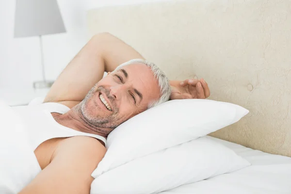 Nahaufnahme eines lächelnden reifen Mannes, der im Bett liegt — Stockfoto