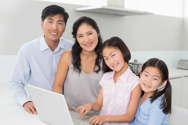 Portrait d'une famille de quatre personnes avec ordinateur portable en cuisine — Photo