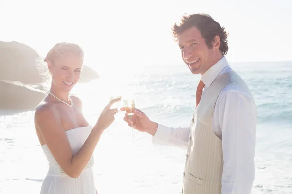 Pasgetrouwden roosteren met champagne glimlachen op camera — Stockfoto