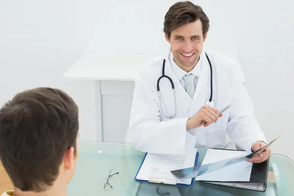 Doctor examining x-ray with patient at office — Stock Photo, Image