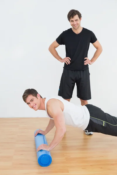 Fisioterapeuta viendo joven hombre hacer flexiones — Foto de Stock