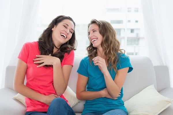 Cheerful friends sitting on sofa in the living room — Stock Photo, Image