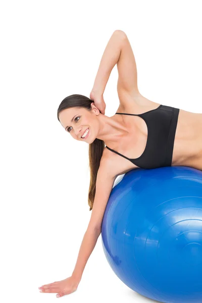 Zijaanzicht van een fit vrouw die zich uitstrekt over fitness bal — Stockfoto