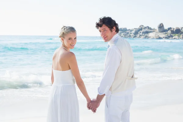 Bruden och brudgummen håller hand tittar på kameran — Stockfoto