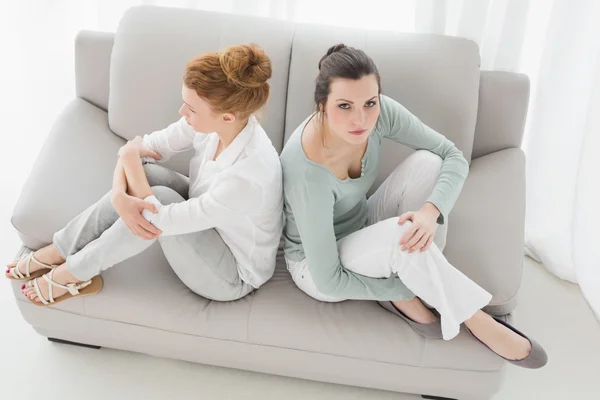 Amigos femeninos infelices que no hablan después de discutir en el sofá —  Fotos de Stock