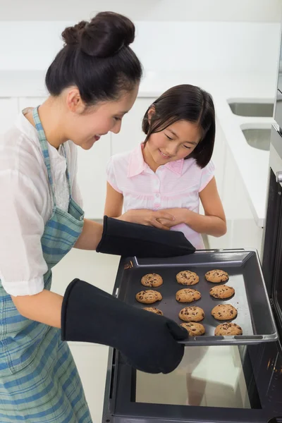 女の子彼女の母の台所でのクッキーの準備を助ける — ストック写真