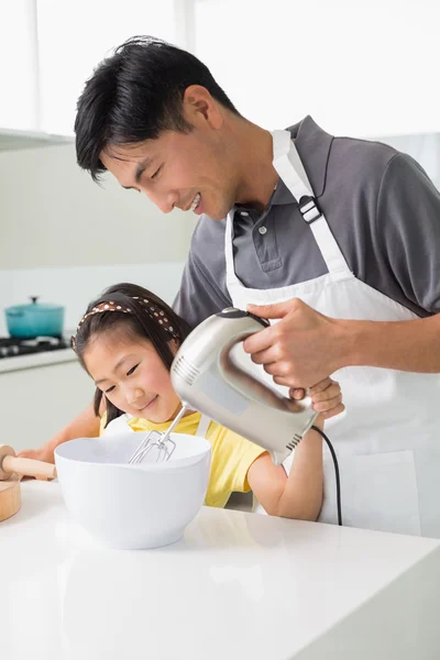 Homme avec fille utilisant fouet électrique dans le bol dans la cuisine — Photo