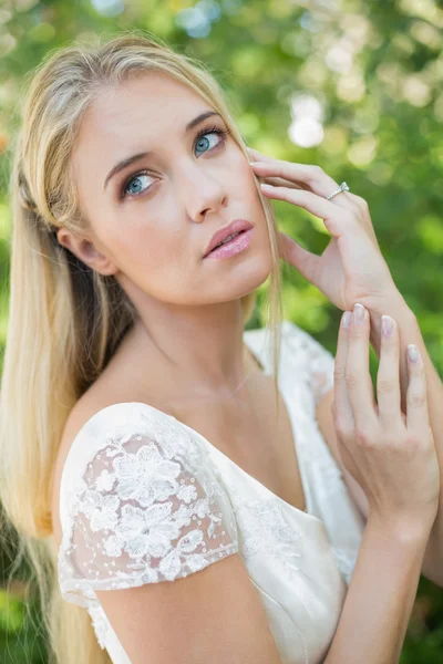 Zufriedene schöne Braut, die ihr Haar berührt und nach oben schaut — Stockfoto