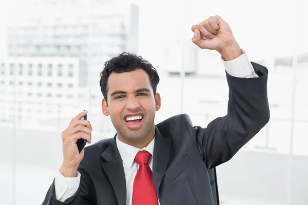 Businessman cheering with clenched fist at office — Stock Photo, Image