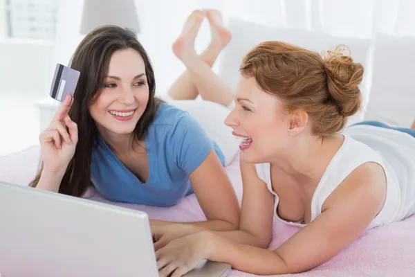 Vrouwelijke vrienden doen online winkelen in bed — Stockfoto