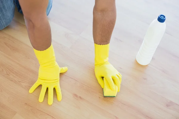 Gants jaunes mains avec éponge nettoyant le sol — Photo