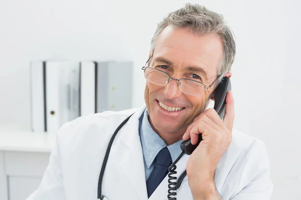 Médico masculino usando teléfono en el consultorio —  Fotos de Stock