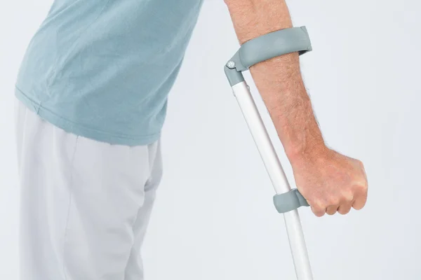 Close-up mid section of a man with crutch — Stock Photo, Image