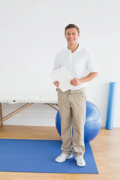 Usmívající se muž trenér s deskami v tělocvičně v nemocnici — Stock fotografie