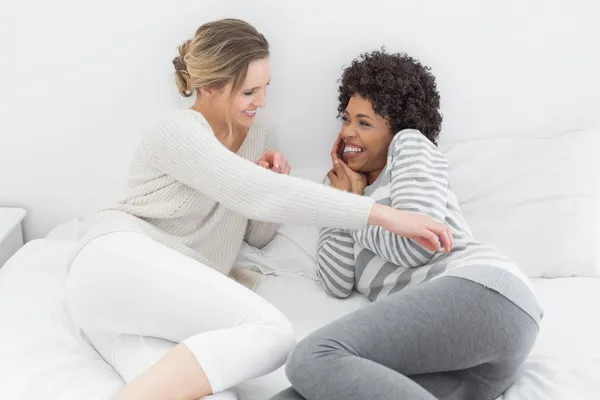 Relaxed female friends enjoying a conversation in bed — Stock Photo, Image