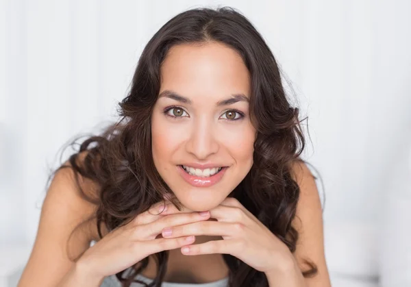 Close-up of a smiling pretty brunette in bed — Stock Photo, Image