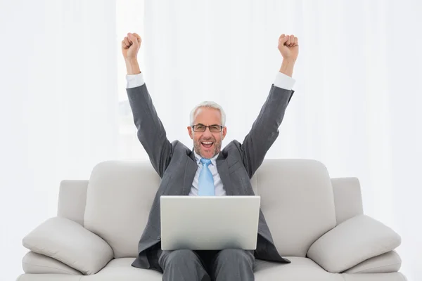 Elegante hombre de negocios animando delante de la computadora portátil en casa —  Fotos de Stock