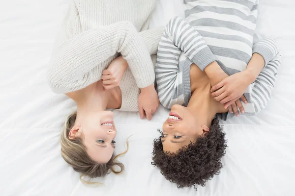 Two casual young female friends lying in bed — Stock Photo, Image