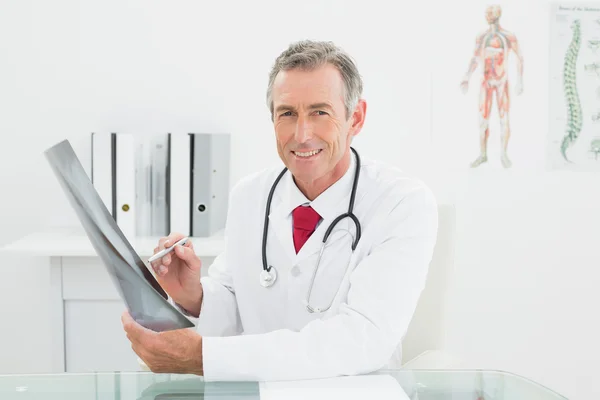Uśmiechający się lekarz z zdjęcie rentgenowskie płuc w biurze — Zdjęcie stockowe