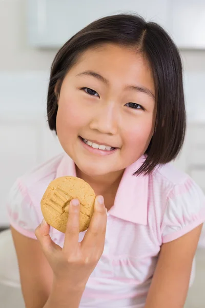 Portrait of a smiling young girl enjoying cookie — Stock Photo, Image