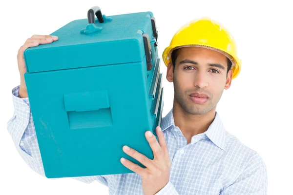 Portrait of a serious handyman in hard hat carrying a toolbox — Stock Photo, Image