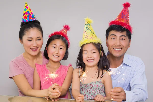 Familj på fyra leker med smällare på en födelsedagsfest — Stockfoto