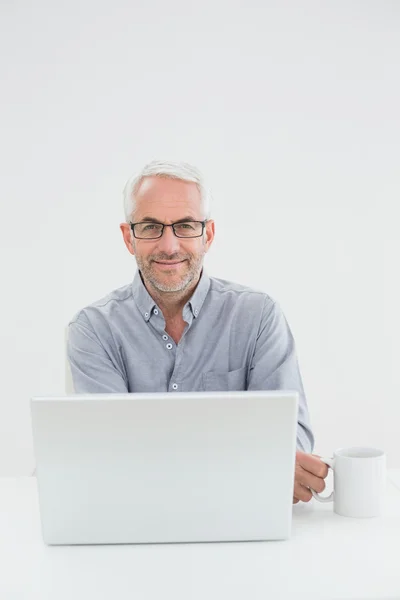 Empresário com laptop e xícara de café — Fotografia de Stock