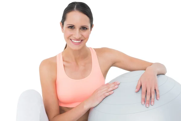 Sorrindo ajuste jovem mulher sentada com bola de fitness — Fotografia de Stock