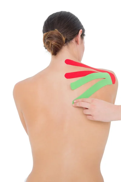 トップレスの女性の肩に赤と緑のストリップとフィットします。 — ストック写真