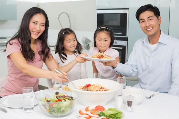 Lycklig familj av fyra njuter spaghetti lunch i han kök — Stockfoto