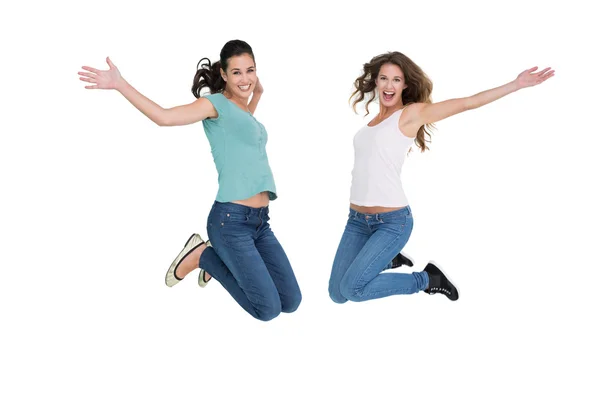 Duas jovens amigas alegres pulando — Fotografia de Stock