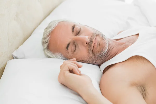 Dojrzały człowiek śpi w łóżku w domu — Zdjęcie stockowe
