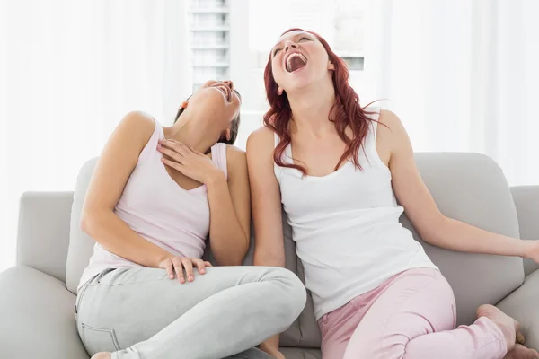 Young female friends laughing in the living room — Stock Photo, Image