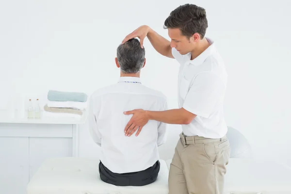 Männlicher Chiropraktiker untersucht reifen Mann — Stockfoto