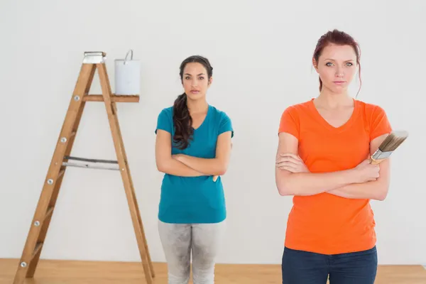 Amigos con pinceles y escalera en una casa nueva — Foto de Stock