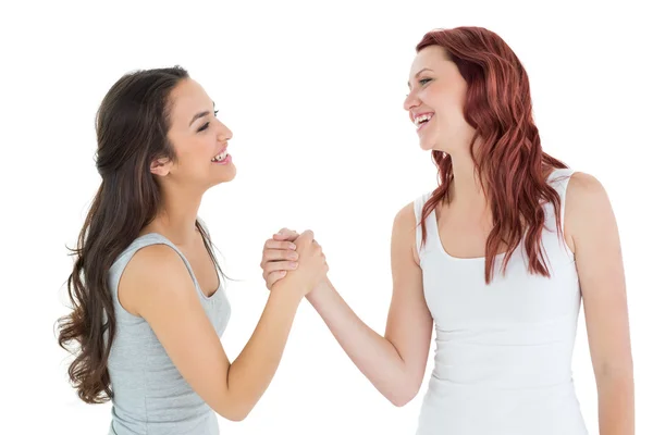 Two cheerful young female friends arm wrestling — Stock Photo, Image