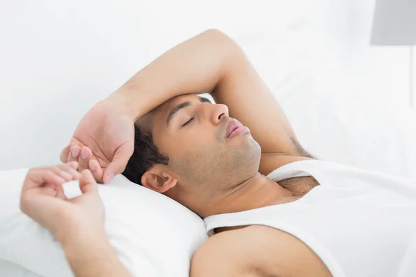 Junger Mann schläft im Bett — Stockfoto