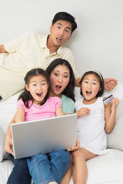 Retrato de família chocada de quatro fazendo compras online — Fotografia de Stock