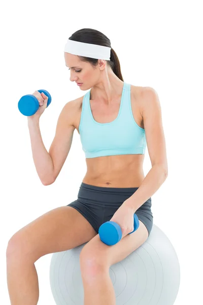 Mujer en forma de ejercicio con mancuernas en la pelota de fitness —  Fotos de Stock