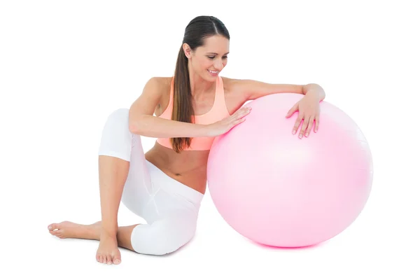Comprimento total de uma mulher em forma sentada com bola de fitness — Fotografia de Stock